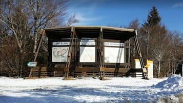 Puinen suojakatos, jossa on opasteet kohteisiin Ski Alpina, Prat-Peyrot ja Ski Nordique.
