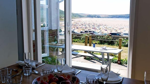 Comedor con vista a la playa y coches aparcados.