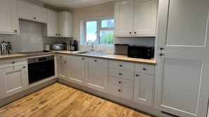 A modern kitchen with white cabinets, a microwave, and a toaster.
