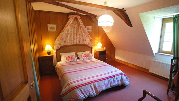 A bedroom with a bed, two bedside lamps, a window, and wooden beams. - --Standard room-- (launay blot)