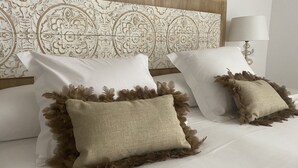 A bed with white linens and two decorative pillows with fringe details. - Corsini & Friends a paradise in the center of Tarragona (Tarragona)