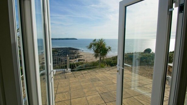 A balcony with a view of the sea and a distant island. - Gorgeous 2 bed apartment with large terrace overlooking Combesgate Beach (Woolacombe)