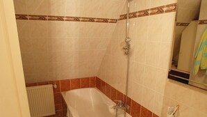 Une salle de bain avec une baignoire, une douche et un lavabo.