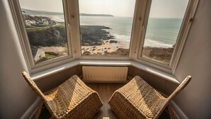 A bay window with a view of a beach and rocky coastline. - Fabulous 3 bed apartment with amazing seaviews and balcony (Woolacombe)