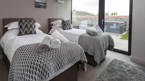 Ein Hotelzimmer mit zwei Betten, einem großen Fenster und Blick auf ein Gebäude.