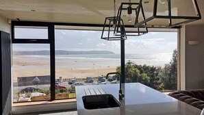Una cocina moderna con un amplio ventanal con vistas a la playa.