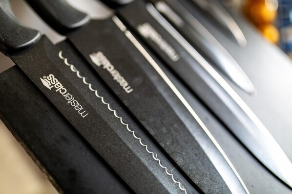 Primer plano de tres cuchillos con bordes dentados y el nombre de la marca "Maserati" visible en los mangos.