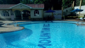 Una piscina cristalina con superficie de agua azul y una escalera.