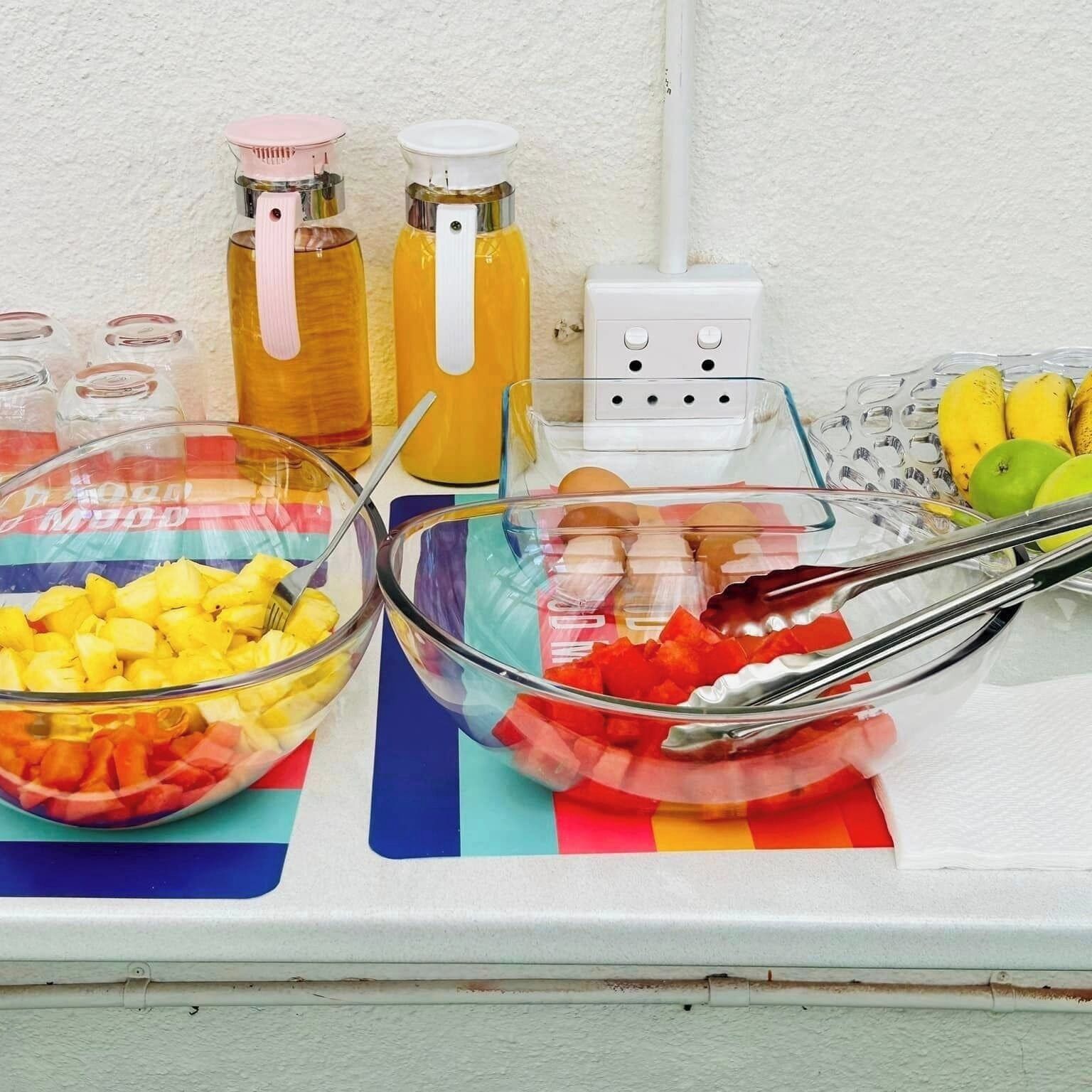 Un buffet de desayuno con cuencos de fruta y salsas.