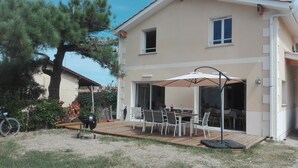 Una casa con patio amueblado y una parrilla.