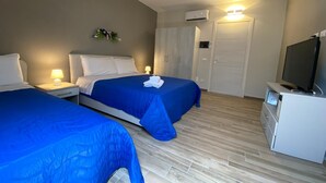 A hotel room with two beds, a TV, a wardrobe, and an air conditioning unit. - HOLIDAY HOME "U SCRUSCIU RO MARI" (Avola)