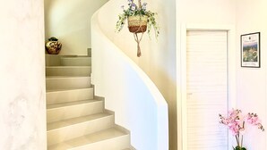 A staircase with a hanging plant, a framed picture, and a potted orchid. - HOLIDAY HOME "U SCRUSCIU RO MARI" (Avola)