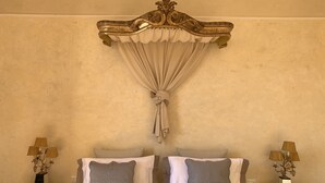 A bed with a canopy, two bedside tables with lamps, and a wall with a textured finish. - DUOMO, MEDIEVAL TOWER Florence: SANTA CROCE in the DONATI TOWER 4th floor w/lift (Firenze)