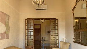 A room with a wooden floor, a chandelier, a large mirror, and two chairs. - DUOMO, MEDIEVAL TOWER Florence: SANTA CROCE in the DONATI TOWER 4th floor w/lift (Firenze)