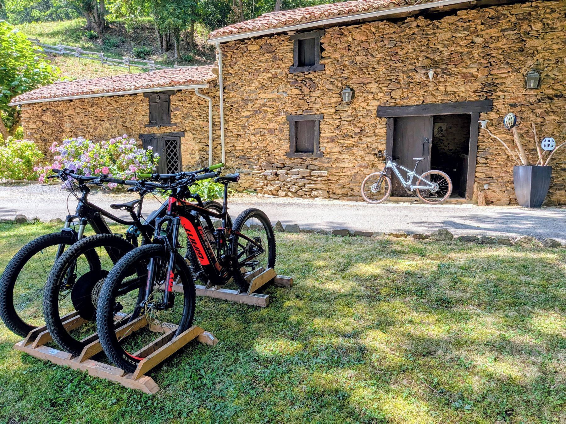 A stone building with a bicycle rack and a parked bicycle.