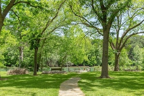 Escape to a serene park setting with a grassy area, stone pathway, and tranquil pavilion.