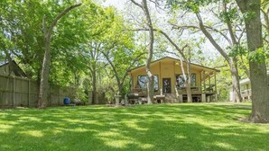 Une maison à deux étages avec un porche couvert et une cour clôturée.