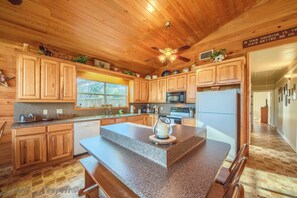 Enjoy cooking in this well-equipped kitchen with a kitchen island, refrigerator, microwave, and dishwasher.
