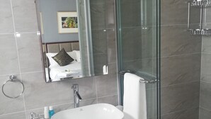 A modern bathroom with a large mirror, a white sink, and a glass shower enclosure. - Azinnia Rivonia Guest House (Sandton)