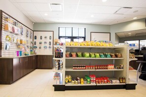 L'intérieur d'une épicerie, avec des étagères remplies d'en-cas, de boissons et d'articles ménagers.