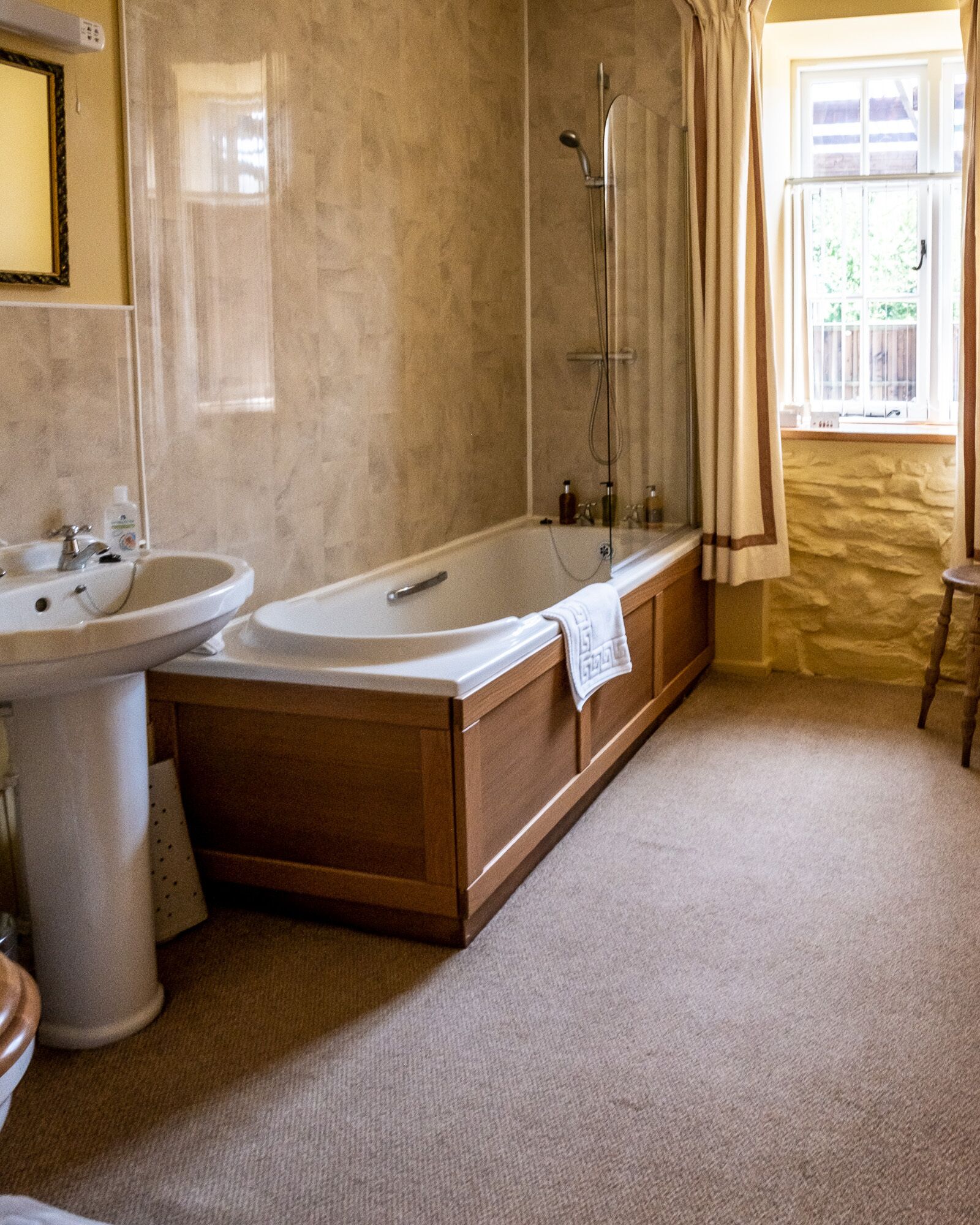 Un baño con bañera, lavabo y espejo.