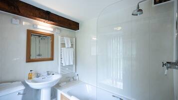 A modern bathroom with a white sink, mirror, and shower.