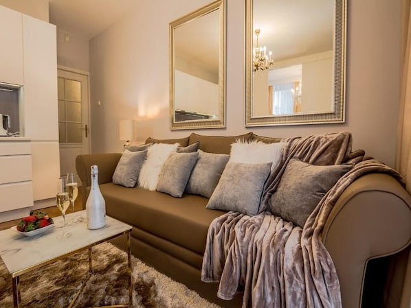 A modern living room with a beige sofa, two large mirrors, a white coffee table, and a fur rug.