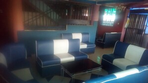 A seating area with blue and white cushioned sofas and a small table. - Rama Restaurant (Nairobi)