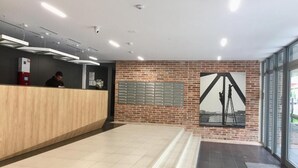 Ett receptionsområde med en bardisk i trä, en tegelvägg och ett stort fönster.