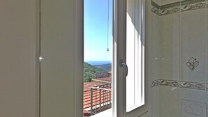 A bathroom with a window offering a view of a balcony and surrounding buildings. - Case Vacanze Borgo Faraldi - Il Pescatore (Villa Faraldi, Liguria)