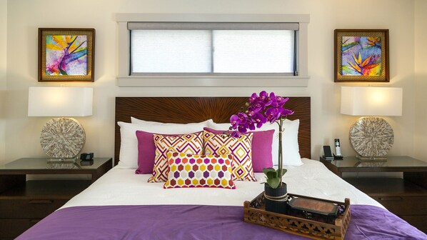 A hotel room with a large bed, two nightstands, a window with blinds, and two wall-mounted lamps.