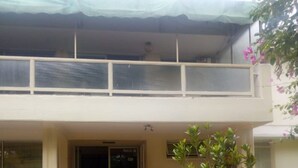 A two-story building with a balcony, potted plants, and a stone-paved entrance. - Homa Bay Tourist Hotel (Homa Bay)