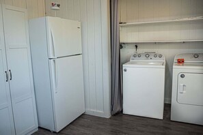 Una cocina compacta equipada con refrigerador, lavadora y horno.