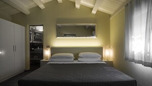 Een slaapkamer met een bed, nachtlampjes, een kledingkast en een spiegel aan de muur.