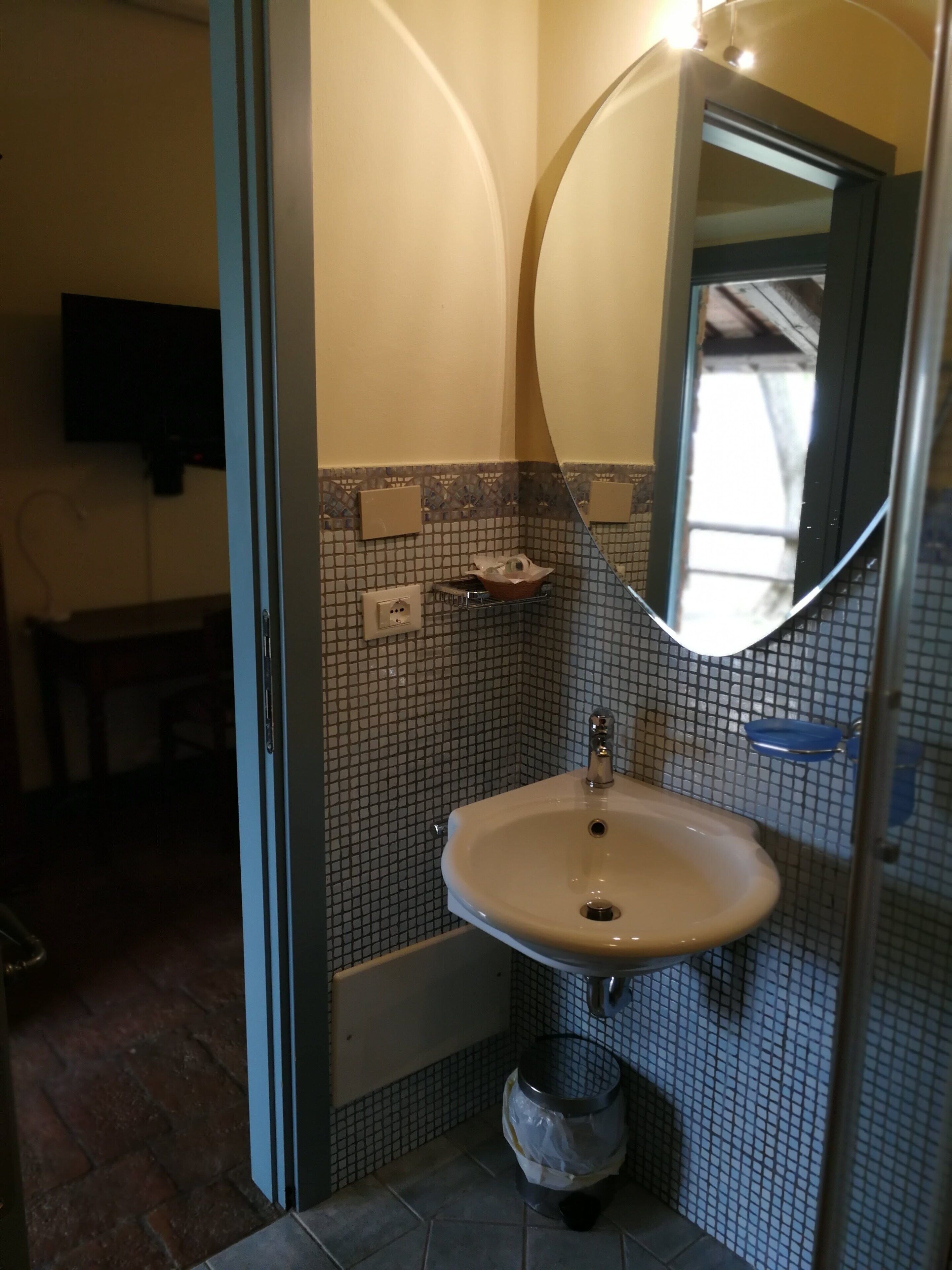 Une salle de bain avec un lavabo, un miroir et des murs carrelés.