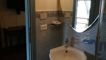 Une salle de bain avec un lavabo, un miroir et des murs carrelés.