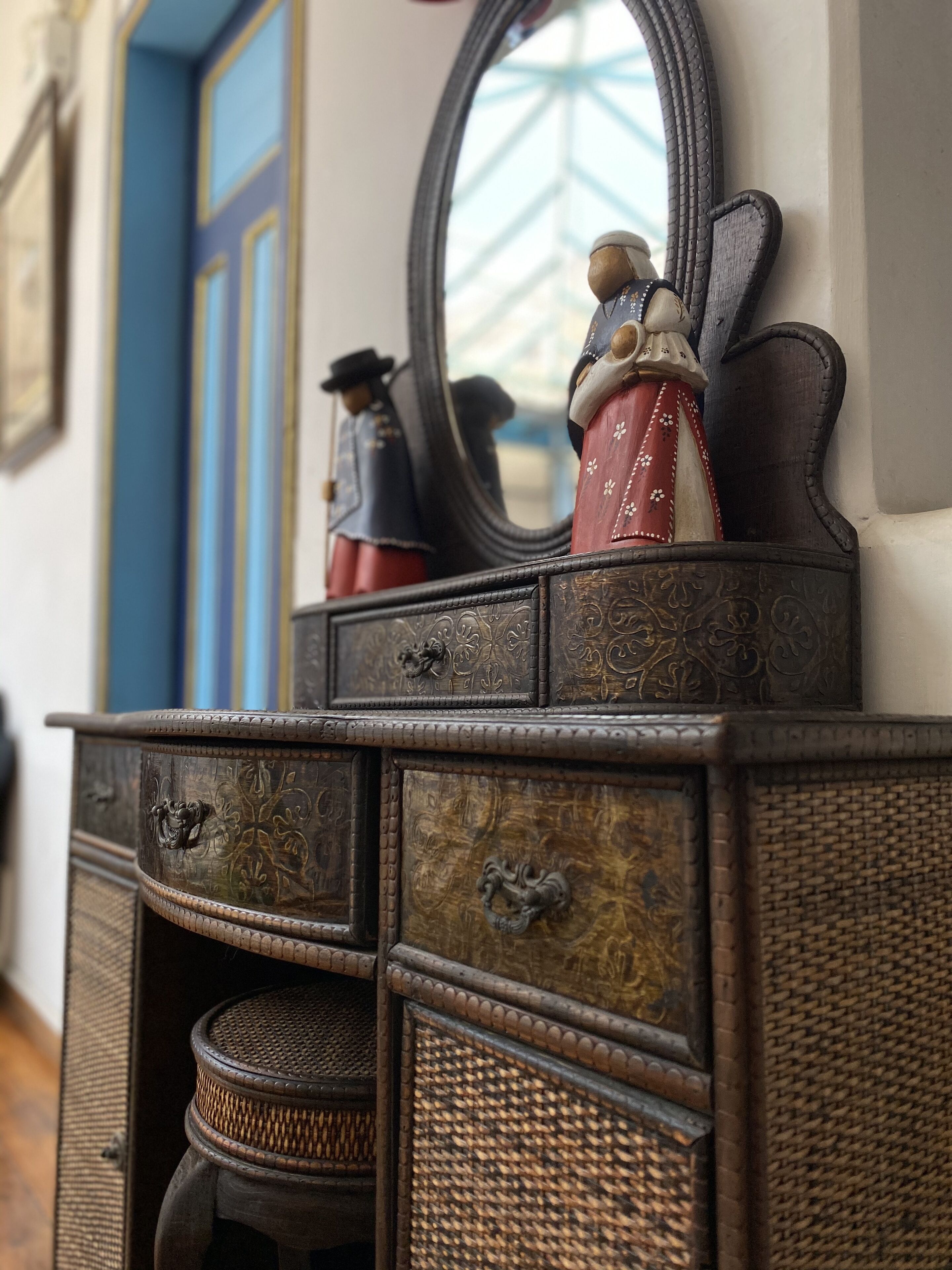 A vintage wooden dresser with intricate carvings and a mirror.