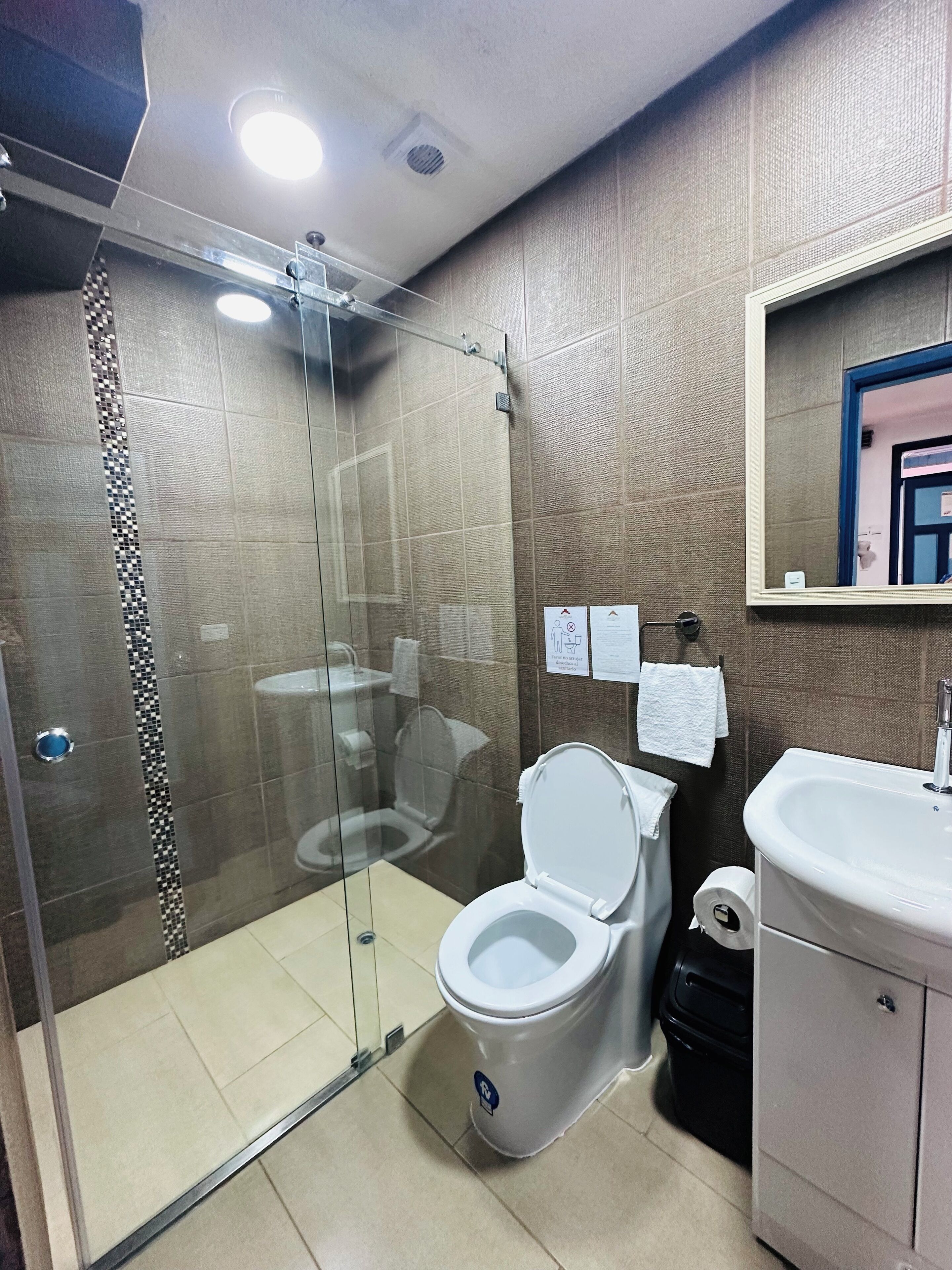 Une salle de bain moderne avec une douche à parois de verre, des toilettes et un lavabo.