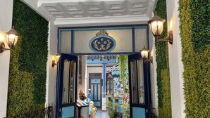 A hallway with a decorative ceiling, green wall accents, and a blue-framed door leading to a room. - Hotel Montecarlo Riobamba (Riobamba)