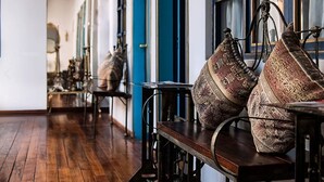 A corridor with wooden flooring, blue doors, and a table with patterned cushions. - Hotel Montecarlo Riobamba (Riobamba)