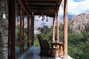 Un área de estar al aire libre cubierta con vistas a montañas y vegetación.