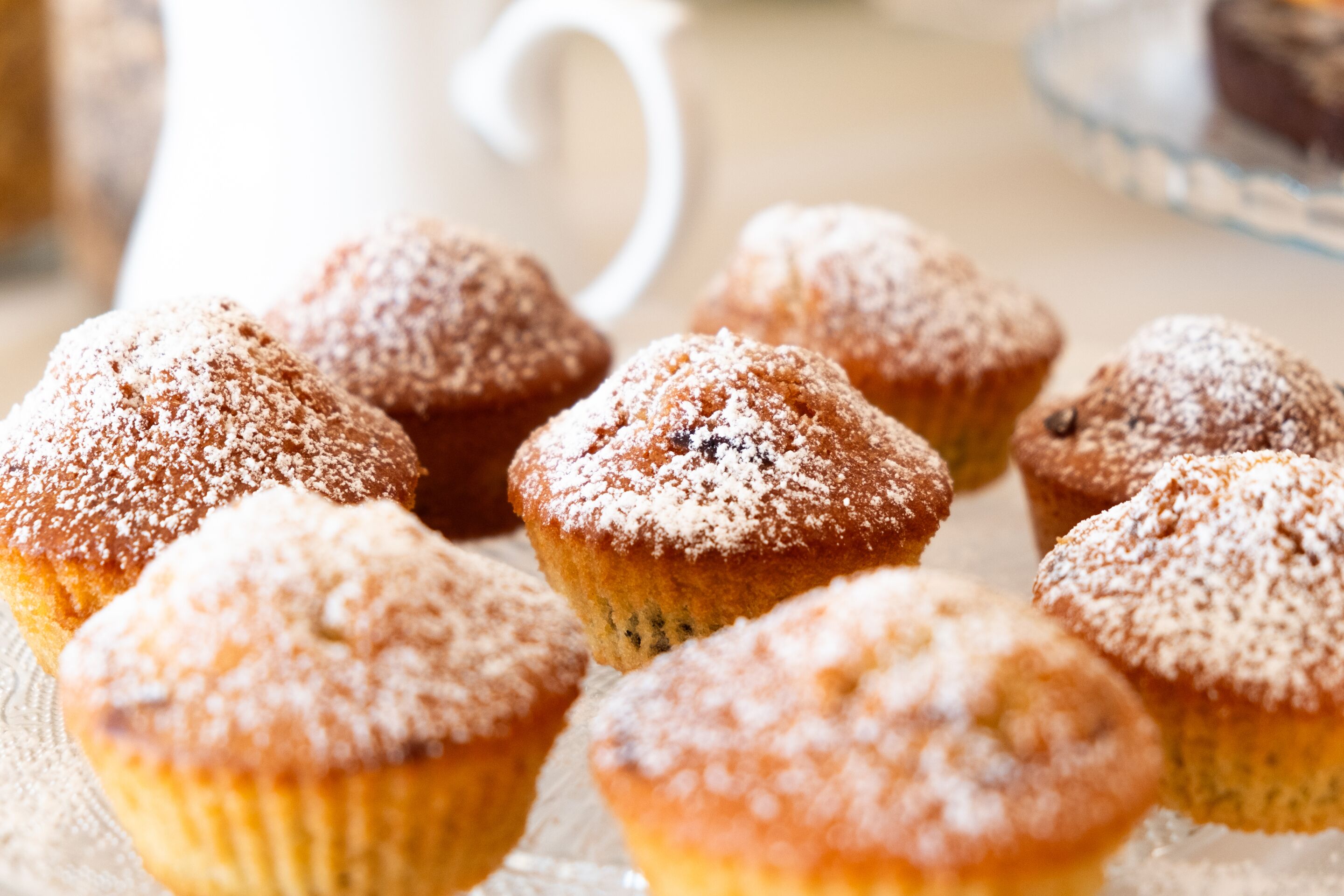 Una bandeja de muffins cubiertos de azúcar glas.