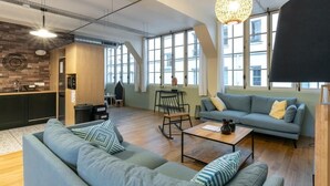 Un salon moderne comprenant un canapé, une table basse et un coin repas avec une table et des chaises.