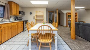 A kitchen with wooden cabinets, a microwave, and a dining table with chairs. - Eagle's Haven - Lower - 2 bedroom, 1 Bath (Cooper Landing)
