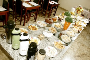 A buffet table with various food items and beverage dispensers.