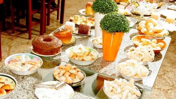 Una mesa de buffet con diversos alimentos y una planta en maceta.