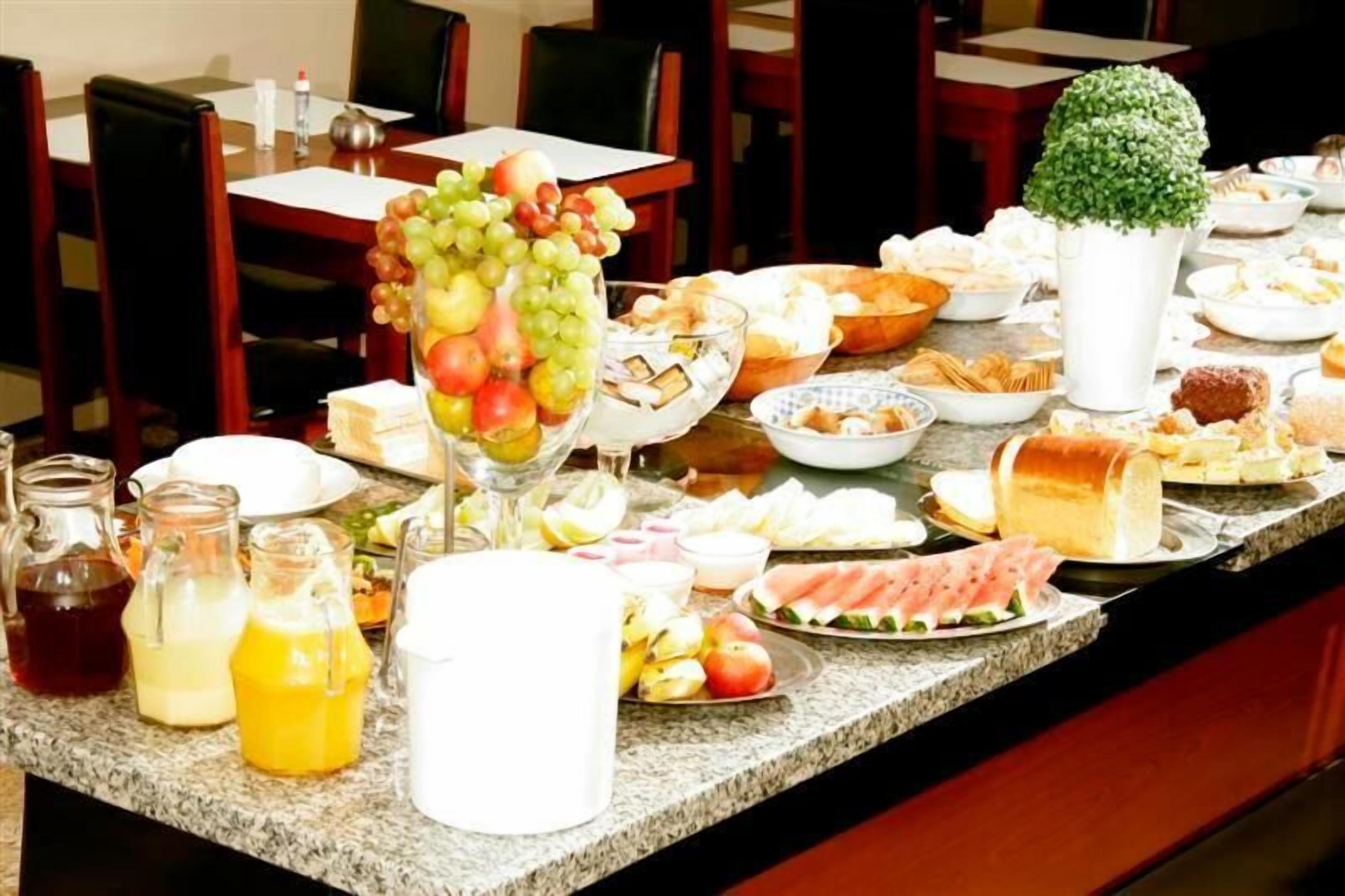 Uma mesa de buffet com diversos alimentos e bebidas.
