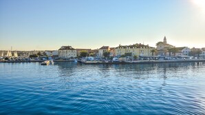 A waterfront cityscape with buildings, a marina, and calm water. - Mobile Home Frangipani 1 (Biograd)
