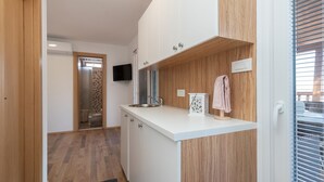 A modern kitchen with wooden cabinets, a white countertop, and a built-in oven.