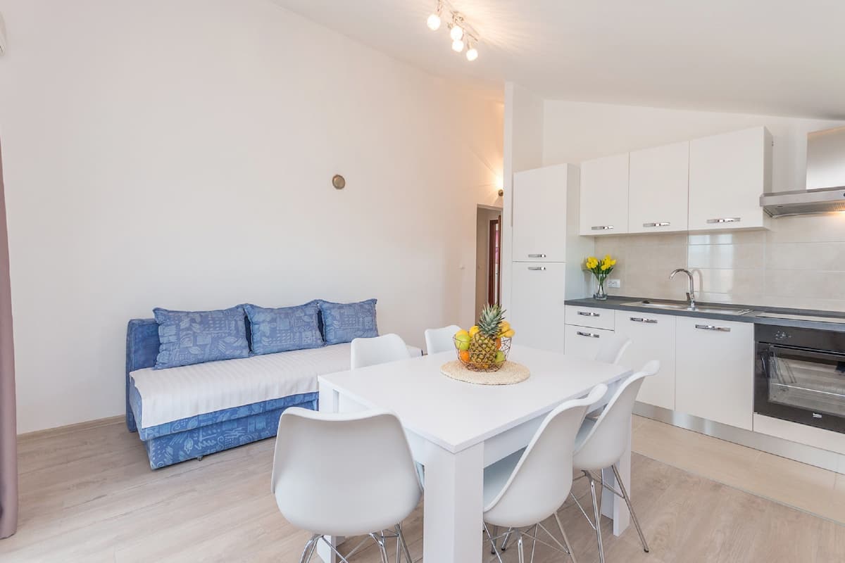 A modern kitchen with white cabinets and a stainless steel oven.